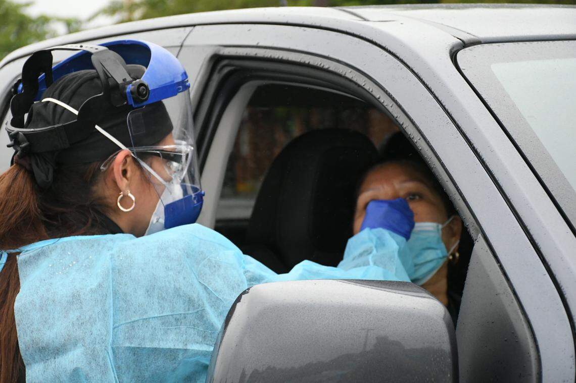 Marta Negrón, enfermera de LliBott Consultorios Médicos adminsiters a COVID-19 test for a Latino patient in the parking lot of Villa Latina Plaza in Raleigh on June 16.