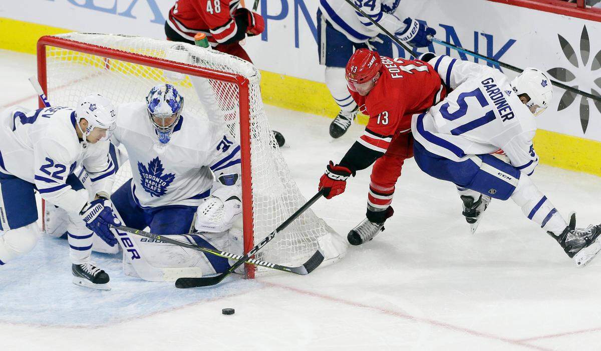 Toronto Maple Leafs’ Nikita Zaitsev (22), of Russia, Jake Gardiner (51) and goalie Frederik Andersen (31), of Denmark, defend the goal from Carolina Hurricanes’ Warren Foegele (13) during the third period of an NHL hockey game in Raleigh, N.C., Tuesday, Dec. 11, 2018. Toronto won 4-1. (AP Photo/Gerry Broome)