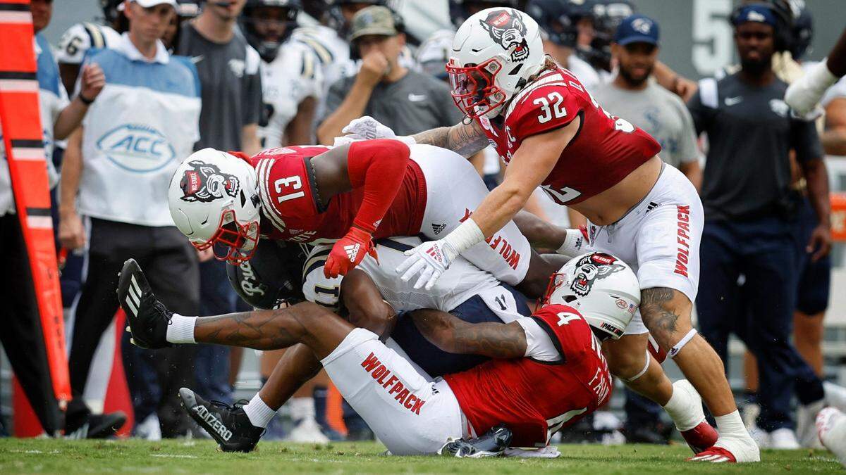 N.C. Stateís Cyrus Fagan (4), Tyler Baker-Williams (13) and Drake Thomas (32) stop Charleston Southern wide receiver Vinson Davis (11) during the first half of N.C. Stateís game against Charleston Southern at Carter-Finley Stadium in Raleigh, N.C., Saturday, Sept. 10, 2022.