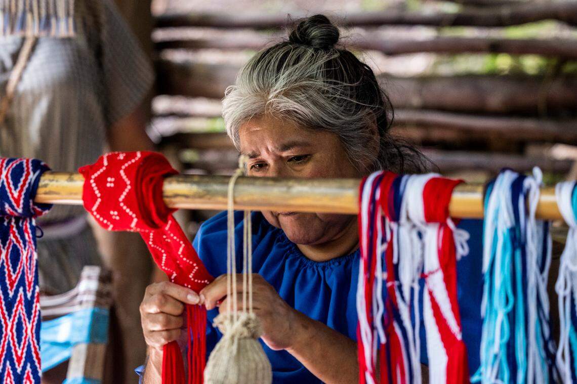 Karen George demonstrates finger weaving during a living history tour at the Oconaluftee Indian Village in Cherokee.