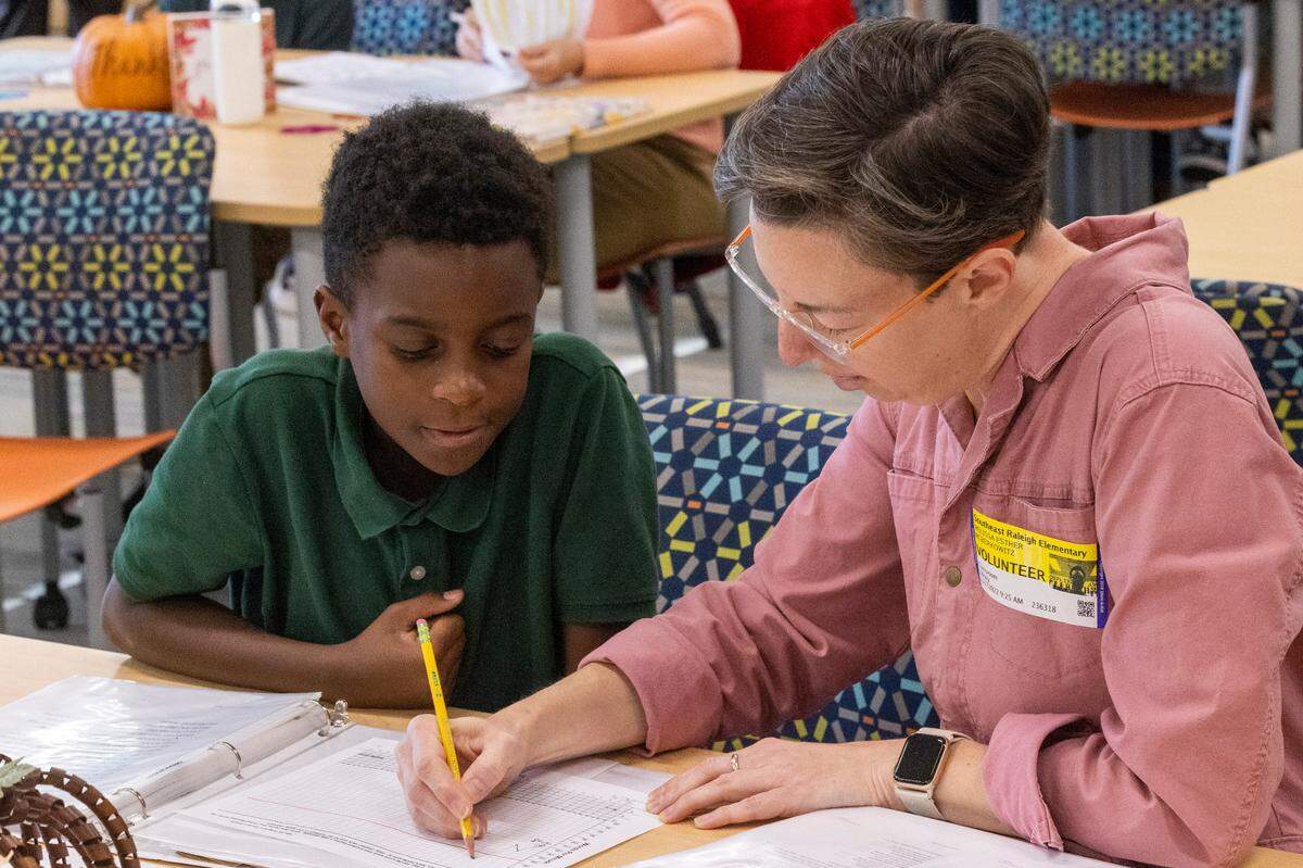 Volunteer tutor Melissa McBerkowitz and Damari White, 10, take part in the new WakeTogether tutoring program designed to help Wake County elementary students recover from pandemic learning loss Thursday, Nov. 17, 2022 at Southeast Raleigh Elementary School.