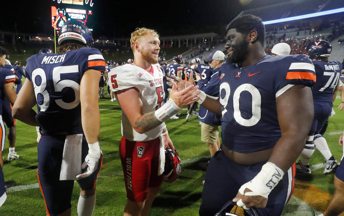 N.C. State quarterback Brennan Armstrong (5) greets Virginia defensive tackle Jahmeer Carter (90) after the Wolfpack’s 24-21 victory over Virginia at Scott Stadium in Charlottesville, Va., Friday, Sept. 22, 2023.