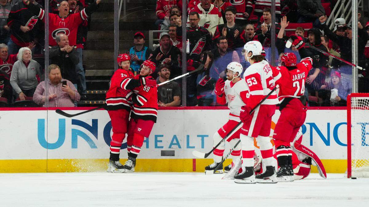 Mar 28, 2024; Raleigh, North Carolina, USA; Carolina Hurricanes center Sebastian Aho (20) is congratulated by left wing Jake Guentzel (59) after his goal against the Detroit Red Wings during the second period at PNC Arena. Mandatory Credit: James Guillory-USA TODAY Sports