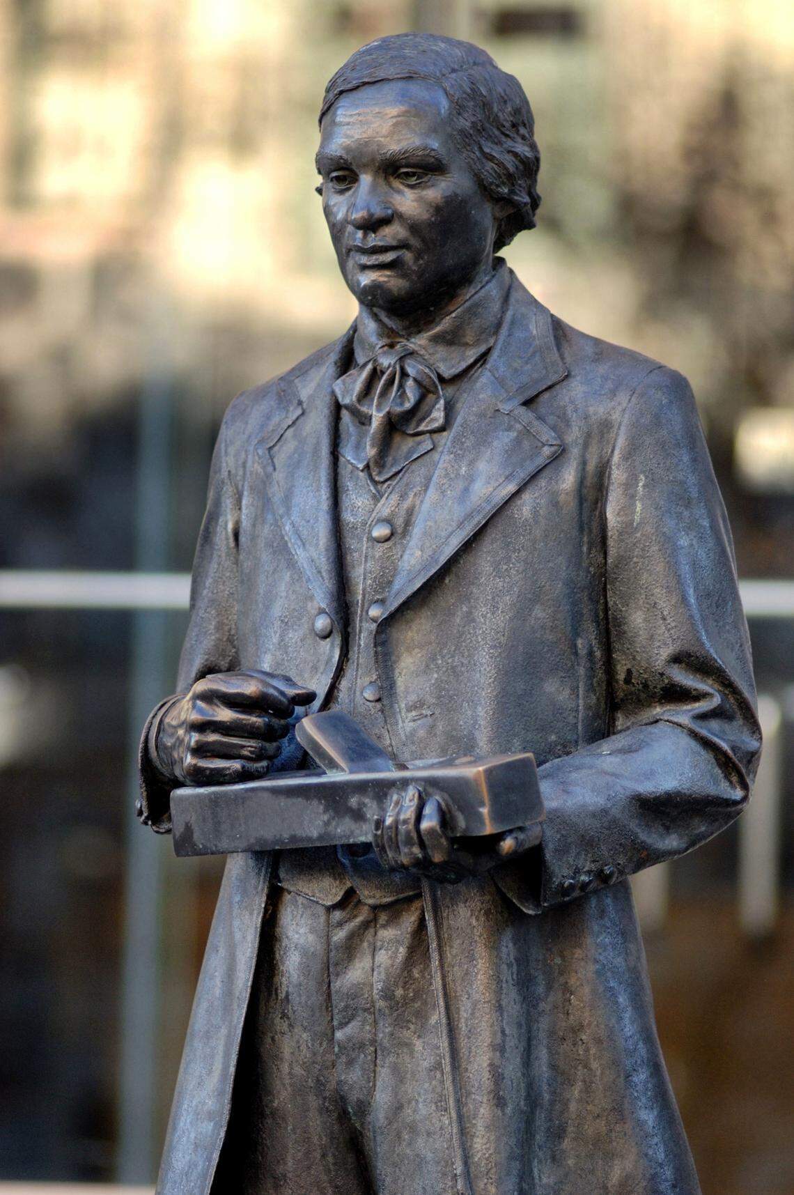 A statue of 19th century furniture maker Thomas Day stands outside the N.C. Museum of History in Raleigh.