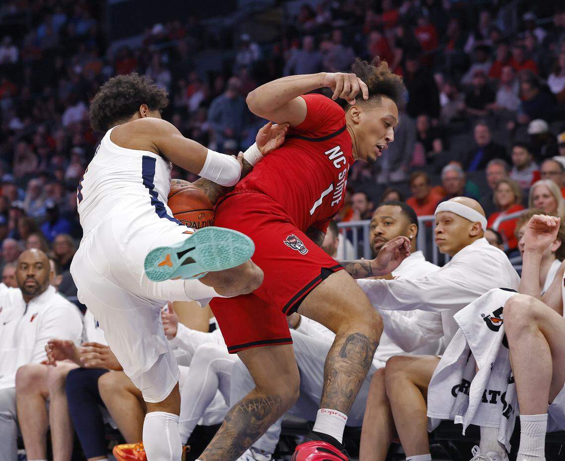 Virginia's Malik Thomas and N.C. State's Darrion Williams tumble out of bounds during the second half of the Wolfpack’s 81-74 loss in the ACC Tournament quarterfinals on Thursday, March 12, 2026, at the Spectrum Center in Charlotte, N.C. 