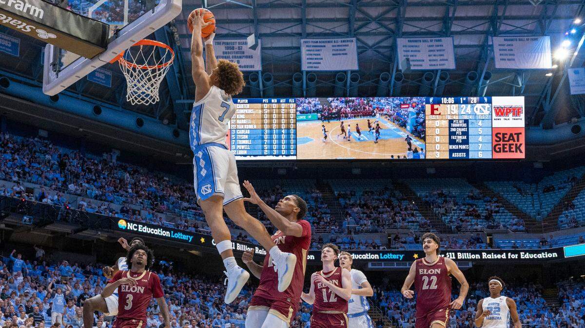 `North Carolina guard Seth Trimble (7) soars to the basket for a dunk over Elon’s Kendall Campbell (1) during the first half on Monday, November 4, 2024 at the Smith Center in Chapel Hill, N.C. Trimble scored 15 points in the Tar Heels’ victory.