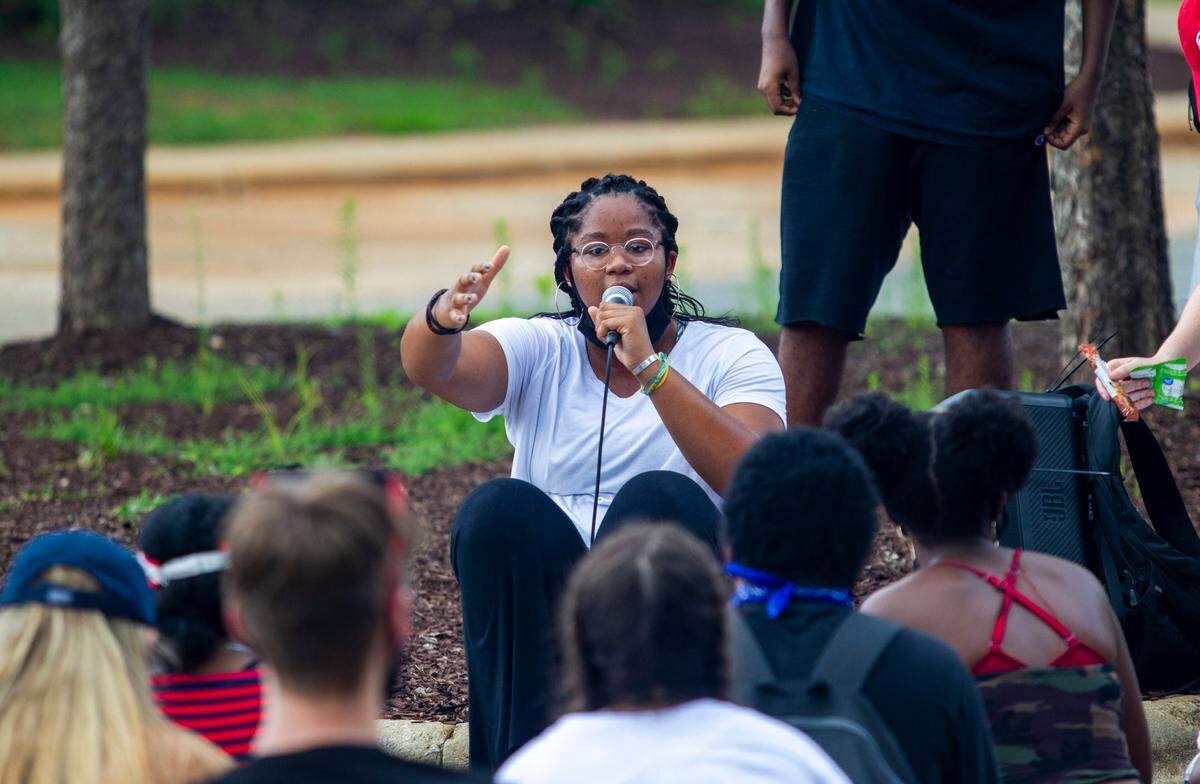 Victoria Smith of the Wake County Black Student Coalition talks with demonstrators as they break from marching at Dillard Drive Middle School in Raleigh Tuesday, July 14, 2020. The protesters marched and hosted a sit-in demanding the Wake County Public School System remove the school resource officer program.