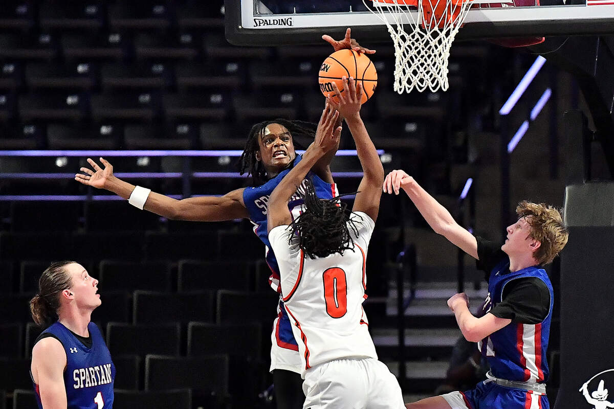 Sanderson’s Malakhi Murphy (30) blocks the shot from New Hanover’s Kellum Brown (0) during the second half. The Sanderson Spartans and the New Hanover Wildcats met in the NCHSAA 4A East Regional Final in Winston-Salem, N.C. on March 12, 2025.