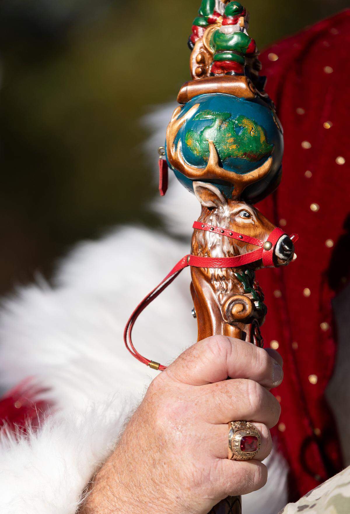 Santa carries a staff with a carving of a reindeer prior to the start of the Raleigh Christmas Parade on Saturday, Nov. 18, 2023.