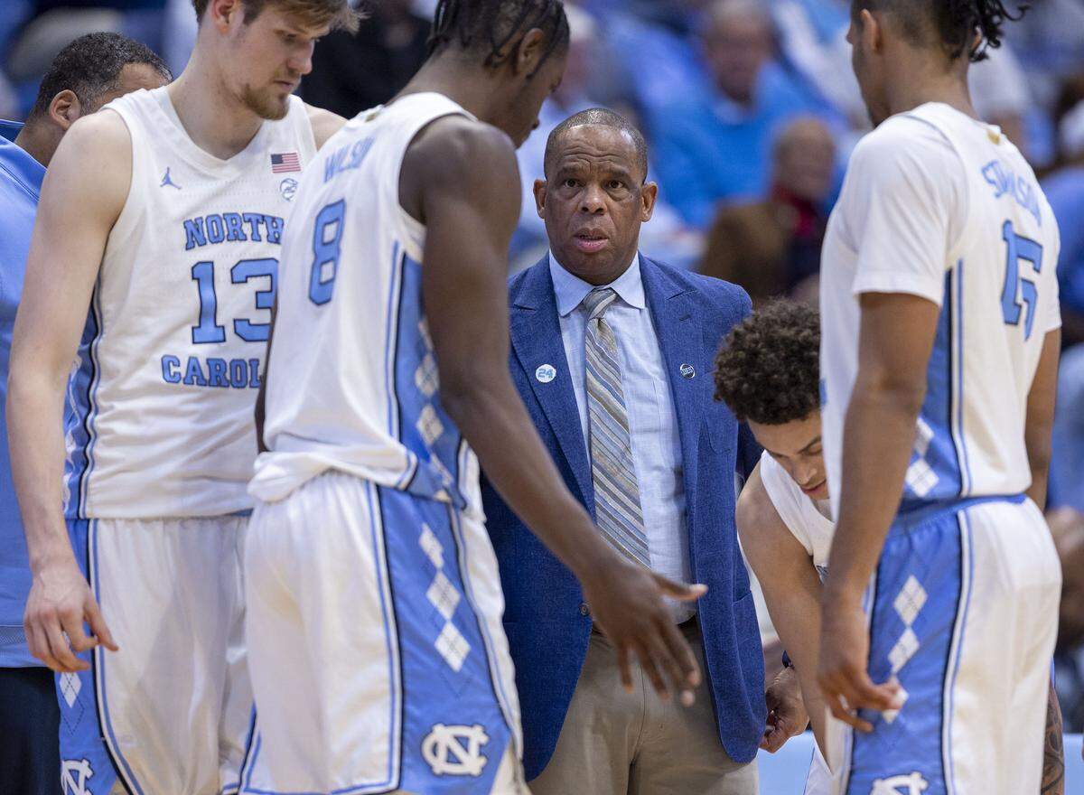North Carolina coach Hubert Davis huddles with players Henri Veesaar (13), Caleb Wilson (8) and Jarin Stevenson (15) in the second half against Navy on Tuesday, November 18, 2025 at the Smith Center in Chapel Hill, N.C.