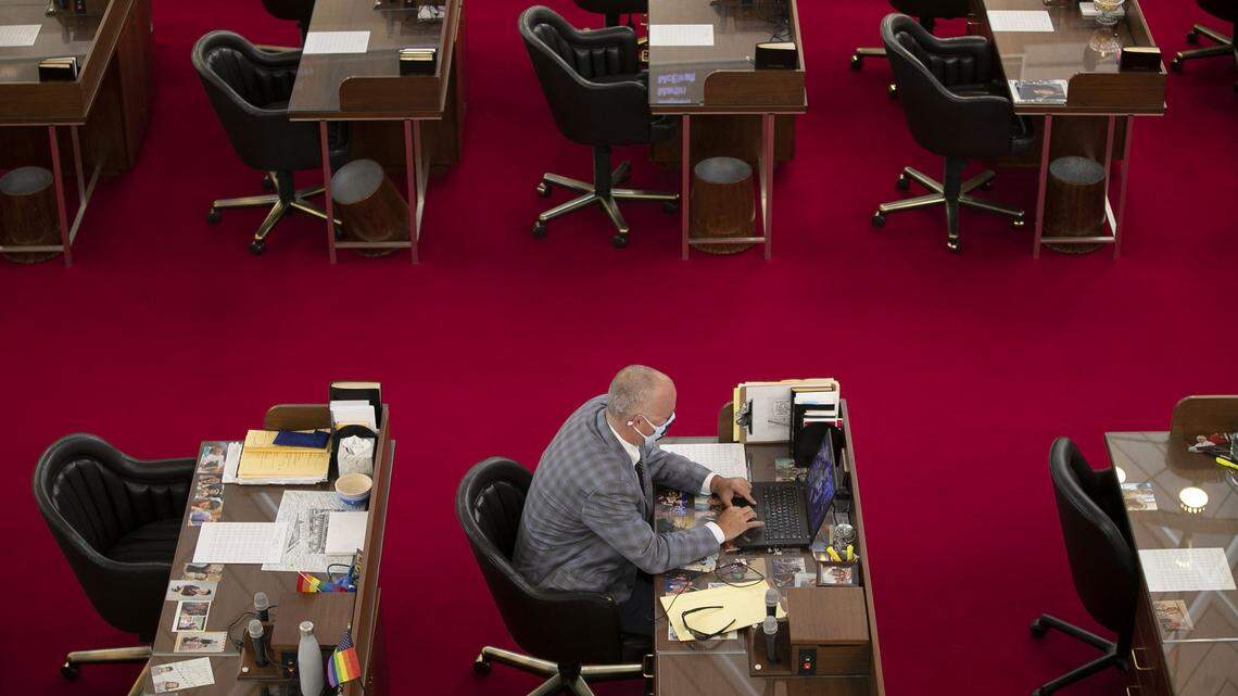 Rep. Darren Jackson of Wake County takes his seat in the House Chamber at 10:30 a.m. ahead of the noon session of the General Assembly on Tuesday, April 28, 2020 in Raleigh, N.C. Jackson said he wanted to get to the chamber early to go through screening, and get ahead of the planned 11 a.m. protest by ReOpen NC outside the Legislature.