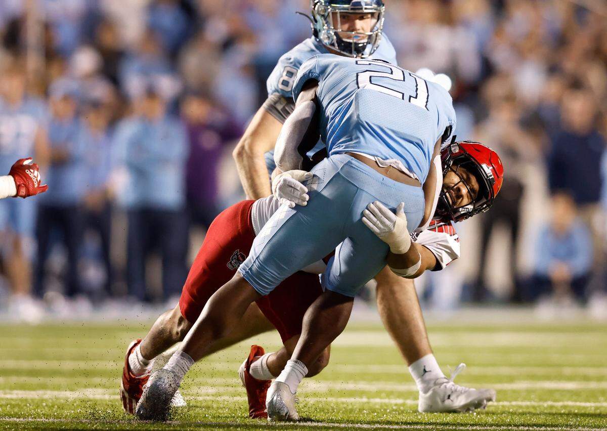 N.C. State safety Tanner Ingle (10) tackles North Carolina running back Elijah Green (21) during the second half of N.C. State’s 30-27 overtime victory over UNC at Kenan Stadium in Chapel Hill, N.C., Friday, Nov. 25, 2022.