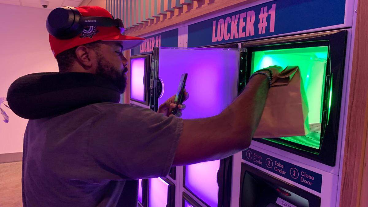 Darryl Beasley of Durham collects a turtle mocha and a bacon, egg and cheese bagel from a locker at the getREEF Virtual Food Hall at Raleigh-Durham International Airport on Thursday, July 21, 2022.