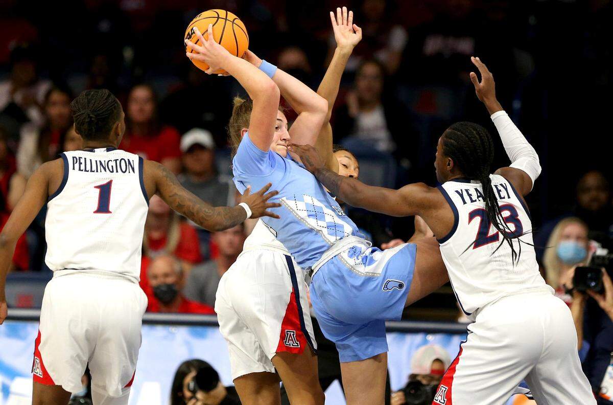 North Carolina guard Alyssa Ustby, center, looks to pass the ball while surrounded by Arizona defenders during a women’s college basketball game in the NCAA tournament hosted in Tucson, Ariz., Monday, March 21, 2022. (Rebecca Sasnett/Arizona Daily Star via AP)