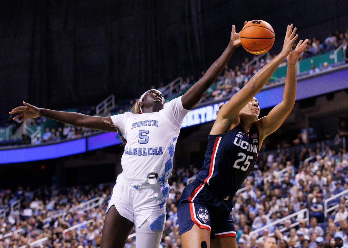 North Carolina’s Maria Gakdeng and UConn’s Ice Brady lunge for a rebound during the first half of the Tar Heel’s game on Friday, Nov. 15, 2024, at First Horizon Coliseum in Greensboro, N.C.