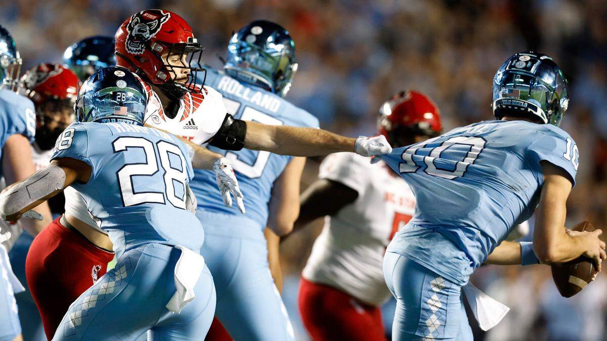 N.C. State linebacker Payton Wilson (11) pressures North Carolina quarterback Drake Maye (10) during the second half of N.C. State’s 30-27 overtime victory over UNC at Kenan Stadium in Chapel Hill, N.C., Friday, Nov. 25, 2022.