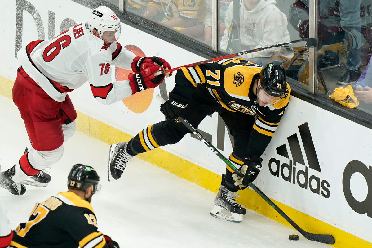 Carolina Hurricanes’ Brady Skjei (76) and Boston Bruins’ Taylor Hall (71) pursue the puck in the third period of Game 4 of an NHL hockey Stanley Cup first-round playoff series, Sunday, May 8, 2022, in Boston. (AP Photo/Steven Senne)