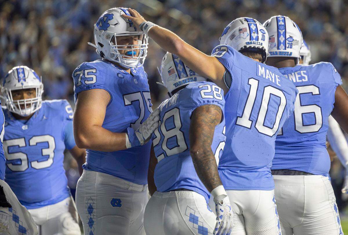 North Carolina quarterback Drake Maye (10) gives offensive lineman Williams Barnes (76) a pat on the head after scoring a touchdown on a three-yard run in the third quarter to give the Tar Heels’ a 24-14 lead over Virginia on Saturday, October 21, 2023 at Kenan Stadium in Chapel Hill, N.C.