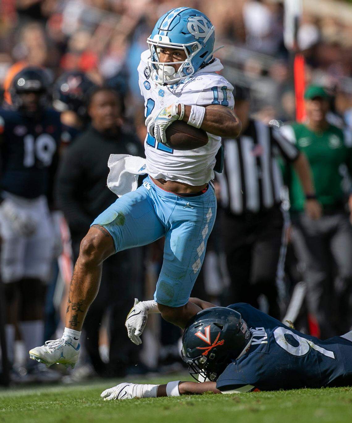 North Carolina’s Josh Downs (11) looks for running room against Virginia’s Coen King (9) after a 32-yard pass reception from quarterback Drake Maye in the third quarter on Saturday, November 5, 2022 at Scott Stadium in Charlottesville, Va. Downs had 15 pass receptions for 166 yards in the Tar Heels’ victory.