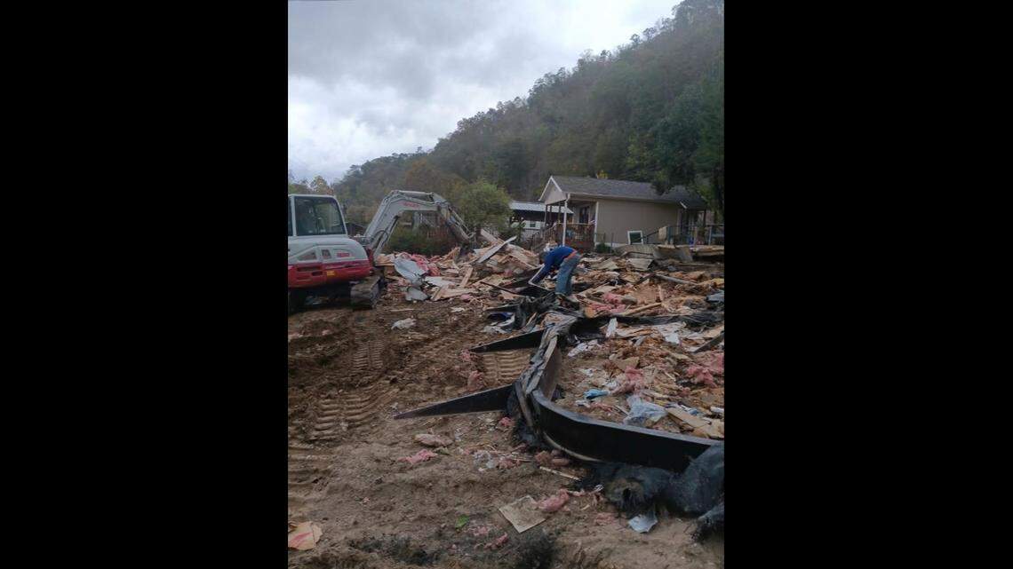 Workers clean up the remains of Linda Brown’s house in Marshall. When Helene hit, the overflowing French Broad River flooded her home.