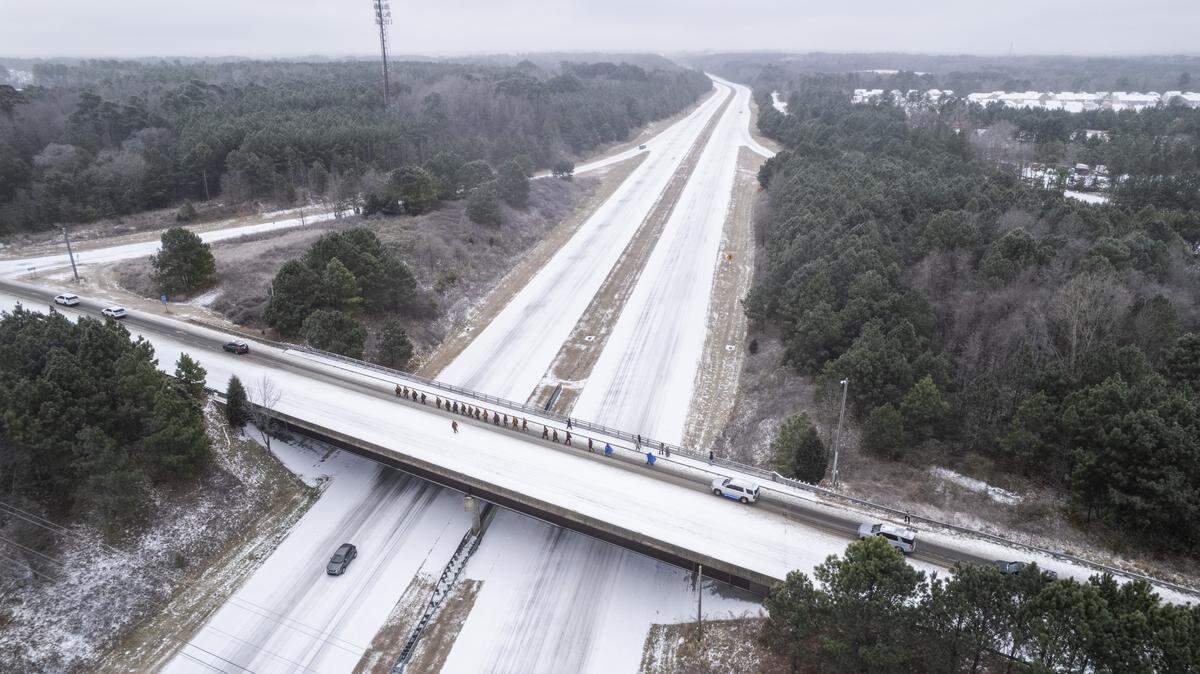 Despite winter weather conditions, a procession of Buddhist monks walks along Buffaloe Road on Sunday, Jan. 25, 2026, in Raleigh. The monks are making a 2,300-mile pilgrimage from Texas to Washington, D.C., as part of the Walk for Peace, an effort to promote peace, compassion and national unity.