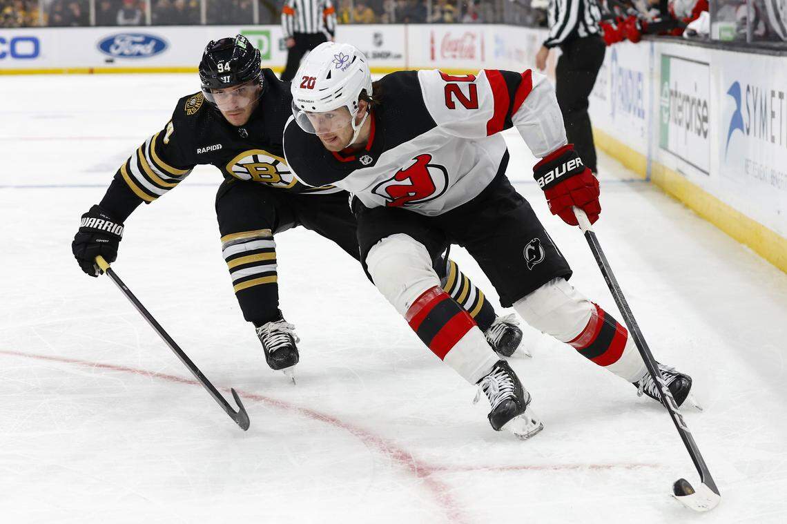 New Jersey Devils center Michael McLeod (20) tries to hold off Boston Bruins center Jakub Lauko (94) during the second period at TD Garden. 