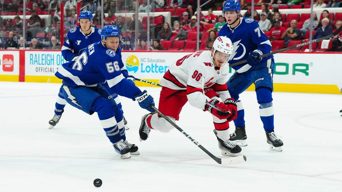 Carolina Hurricanes center Jack Roslovic (96) Tampa Bay Lightning forward Jesse Yvonne (56) and defenseman Emil Lilleberg (78) chase after the puck during the third period at PNC Arena.