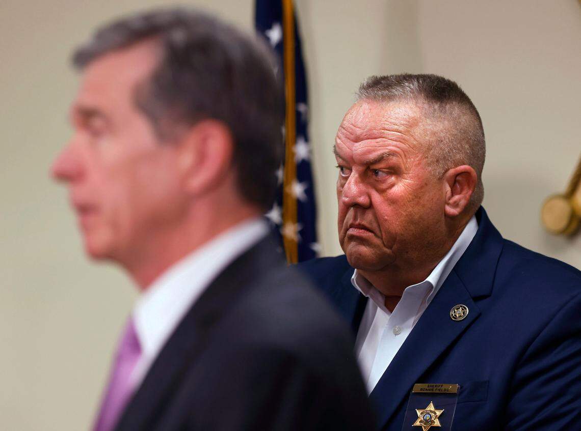 Moore County Sheriff Ronnie Fields stands with Gov. Roy Cooper during a press conference about the power outage in Moore County on Monday, Dec. 5, 2022, in Carthage, N.C.