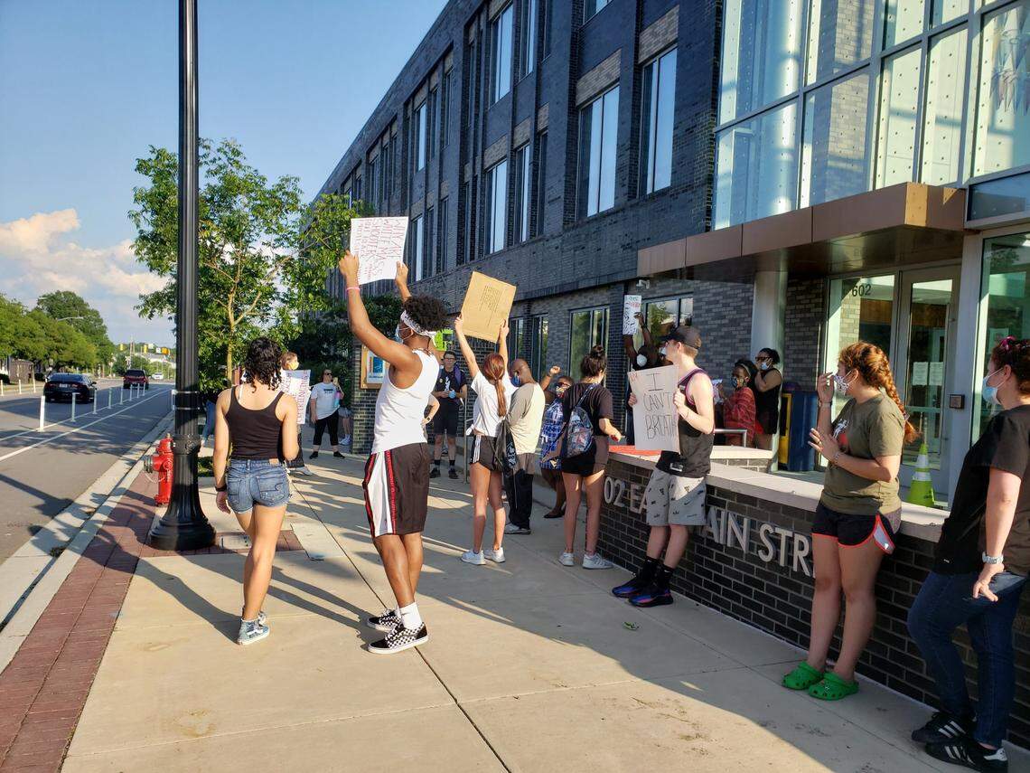 Protesters have walked on the sidewalk from CCB Plaza to Durham police headquarters holding signs and chanting in downtown Durham, June 5, 2020.