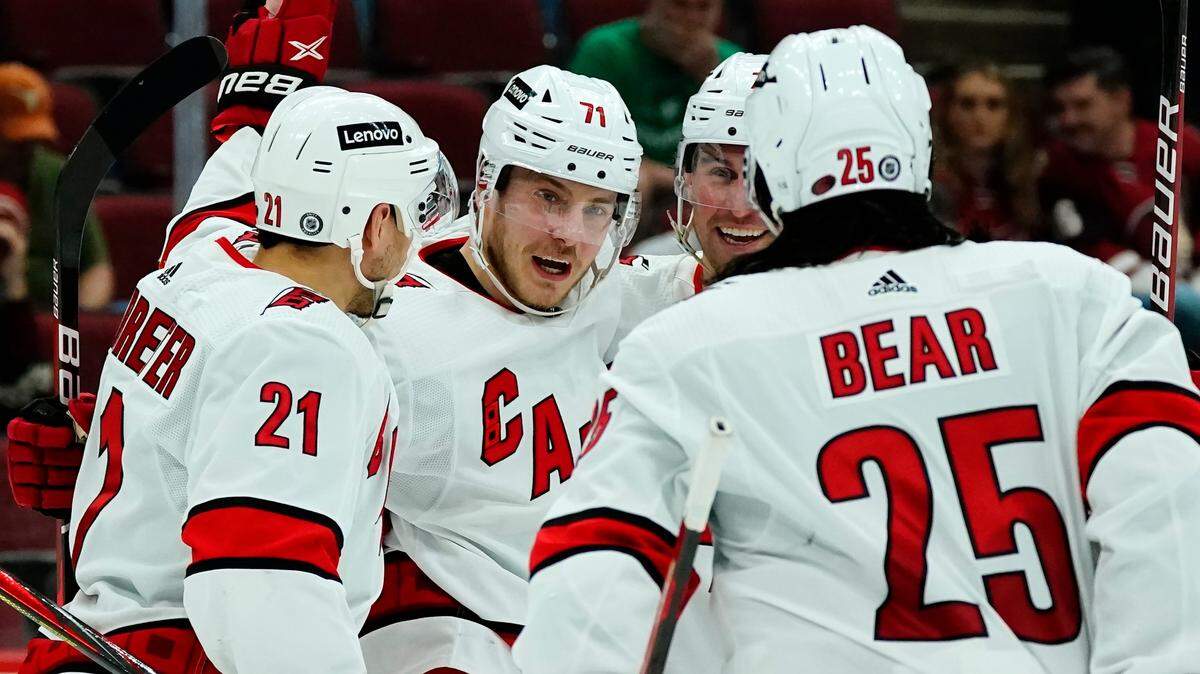Carolina Hurricanes right wing Jesper Fast (71) celebrates his goal against the Arizona Coyotes with Hurricanes right wing Nino Niederreiter (21), defenseman Ethan Bear (25), and defenseman Brendan Smith, back right, during the second period of an NHL hockey game Monday, April 18, 2022, in Glendale, Ariz. (AP Photo/Ross D. Franklin)