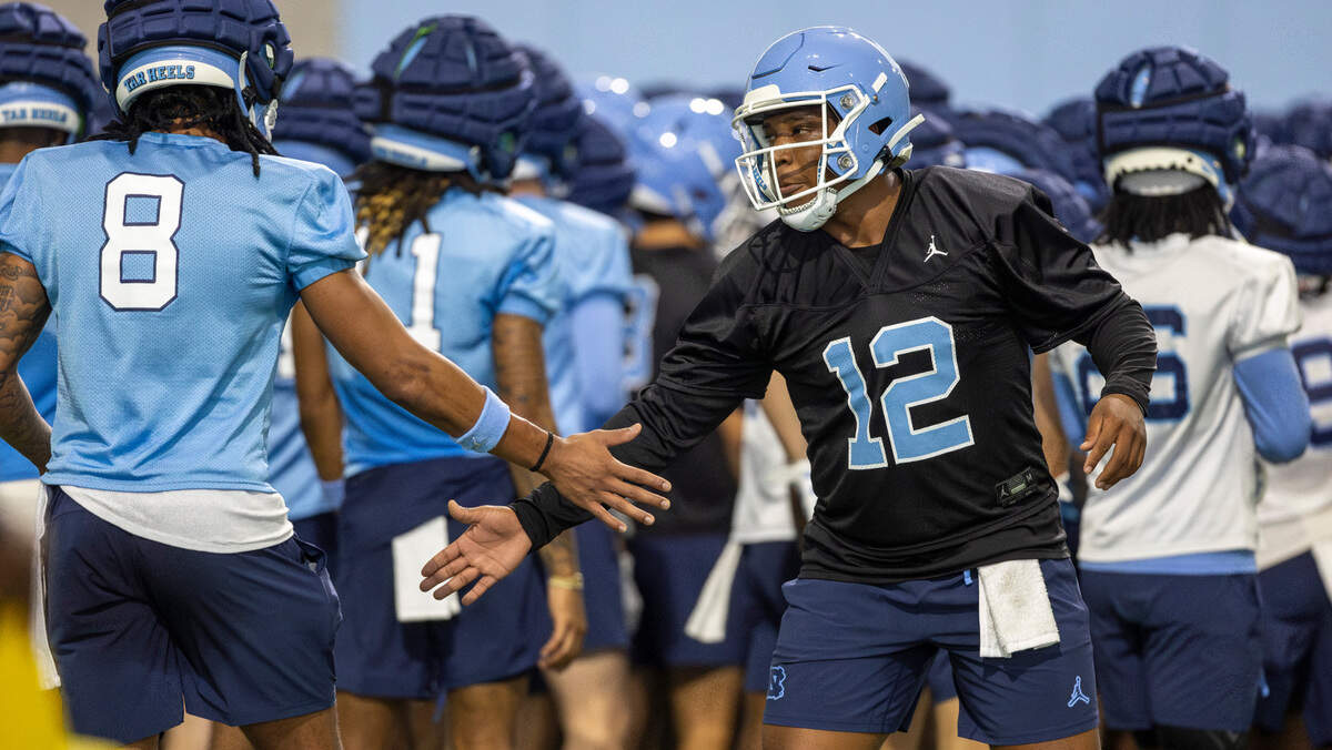 North Carolina graduate transfer quarterback Jacolby Criswell (12) greets receiver Kobe Paysour (8) during the Tar Heels’ first practice of the season on Monday, July 29, 2024 in Chapel Hill, N.C.