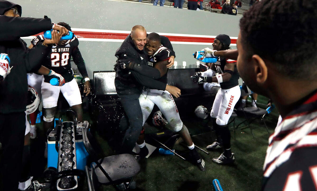 N.C. State head coach Dave Doeren celebrates with N.C. State linebacker Isaiah Moore (1) as time runs out in N.C. State’s 23-13 victory over Georgia Tech at Carter-Finley Stadium in Raleigh, N.C., Saturday, Dec. 5, 2020.