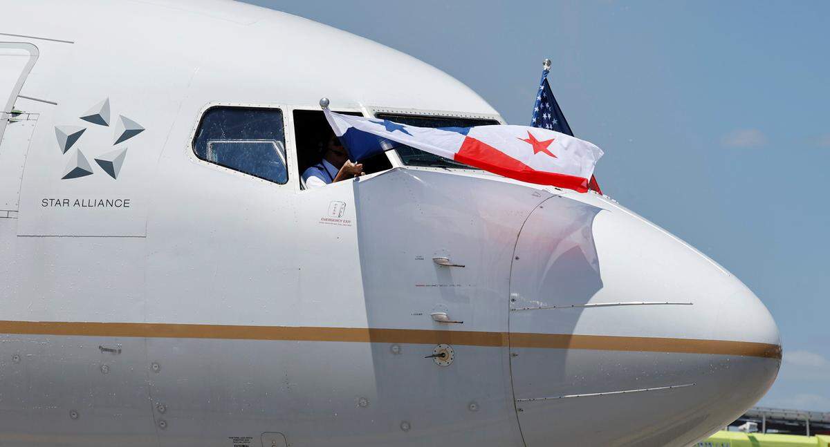 The flight crew of the inaugural Copa Airlines flight from Panama City, Panama to Raleigh-Durham International Airport wave the Panamanian and American flags as the plane arrives at their gate at the airport Friday, June 21, 2024.