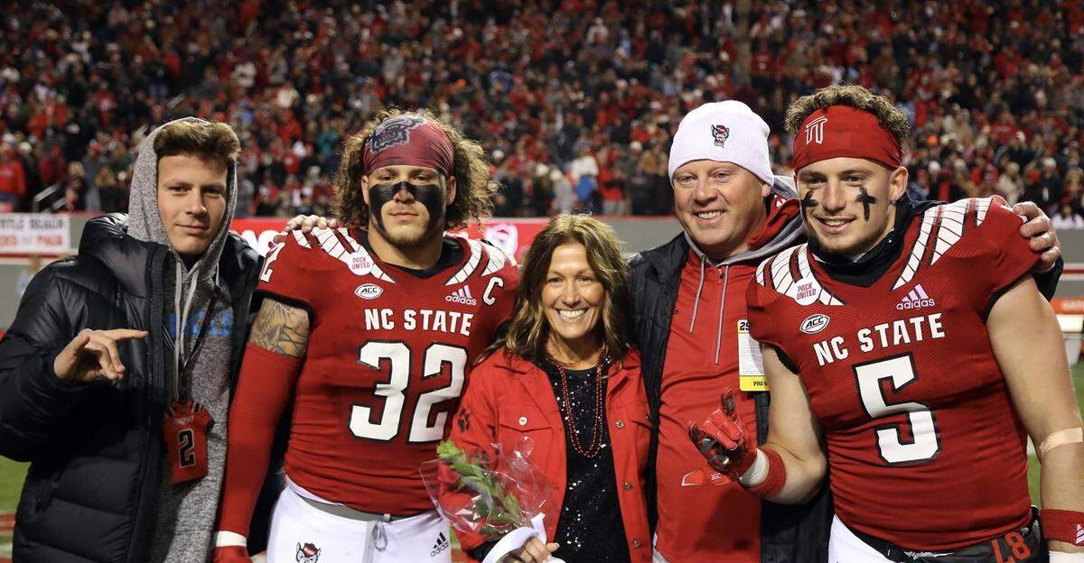 The Thomas family poses for a photo on the field at Carter-Finley Stadium on the campus of N.C. State University in Raleigh, N.C. Lex Thomas, left, is a senior quarterback for Heritage High School in Wake Forest, and has been recruited to play at N.C. State. Drake (32) and Thayer (5) play for the Wolfpack. Also in the photo are the players’ mother, Shelly, and father, Trevor.