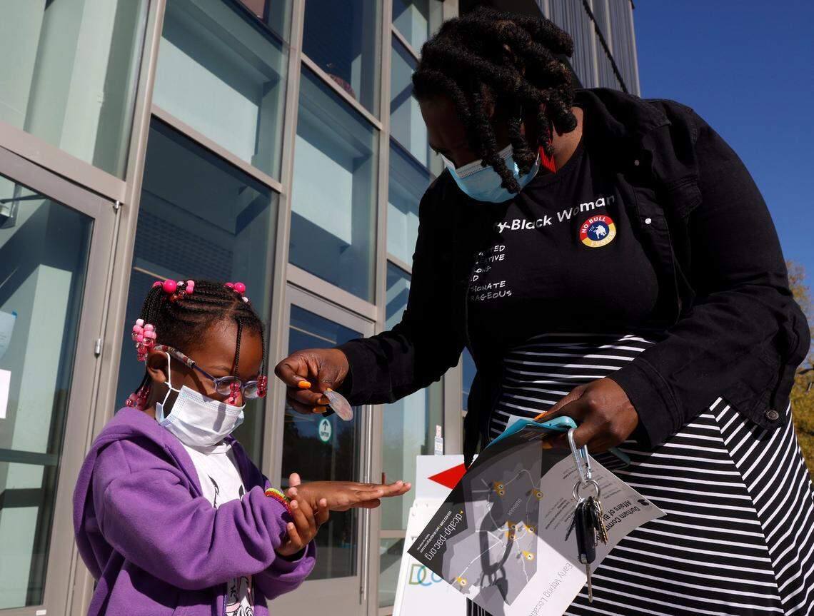 Joy Spencer places a voting sticker on the hand of her daughter, Kaliah, 4, outside of the Durham County Main Library on Tuesday, Nov. 8, 2022, in Durham, N.C.