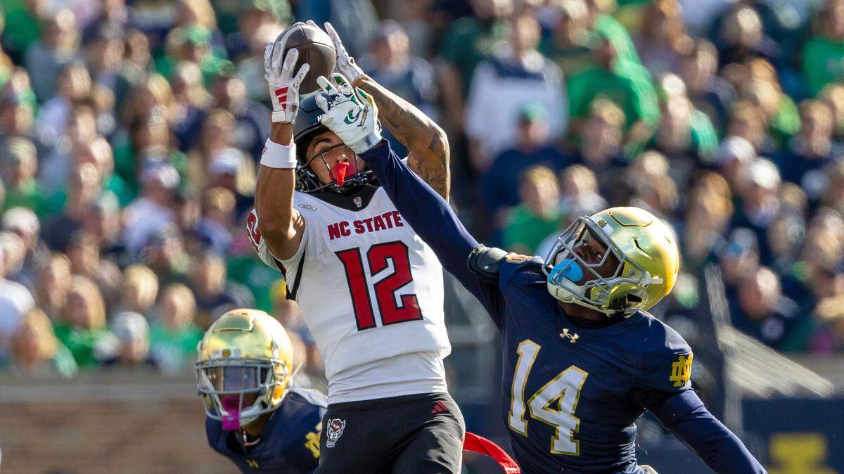 NC State Wolfpack wide receiver Teddy Hoffmann (12) makes a catch while defended by Notre Dame Fighting Irish cornerback Dallas Golden (14) during their game at Notre Dame Stadium.