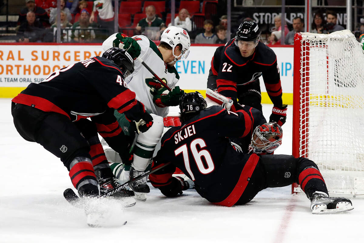 Carolina Hurricanes’ Brett Pesce (22), Brady Skjei (76), and Jordan Martinook (48) help goaltender Frederik Andersen (31) keep the puck controlled by Minnesota Wild’s Joel Eriksson Ek (14) out of the net during the first period of an NHL hockey game in Raleigh, N.C., Saturday, April 2, 2022. (AP Photo/Karl B DeBlaker)