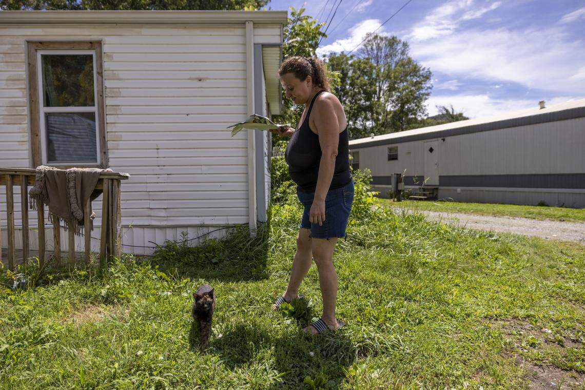 April Roe, a resident of Good Loop in Swannanoa, stands outside the mobile home she shares with her daughter, granddaughter and uncle on Aug. 13.