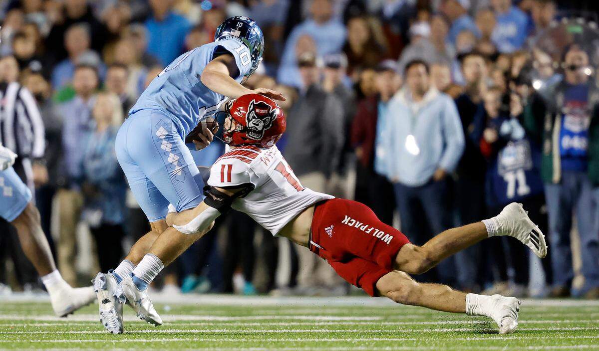 N.C. State linebacker Payton Wilson (11) tackles North Carolina quarterback Drake Maye (10) during the second half of N.C. State’s 30-27 overtime victory over UNC at Kenan Stadium in Chapel Hill, N.C., Friday, Nov. 25, 2022.
