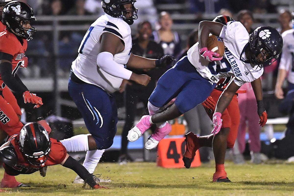 Millbrook running back Brilison Mccullers (3) leaps after being tripped up by Rolesville linebacker Talyn Watkins (22) during the first half. The Rolesville Rams and the Millbrook Wildcats met in a football game in Raleigh. N.C. on October 11, 2024.