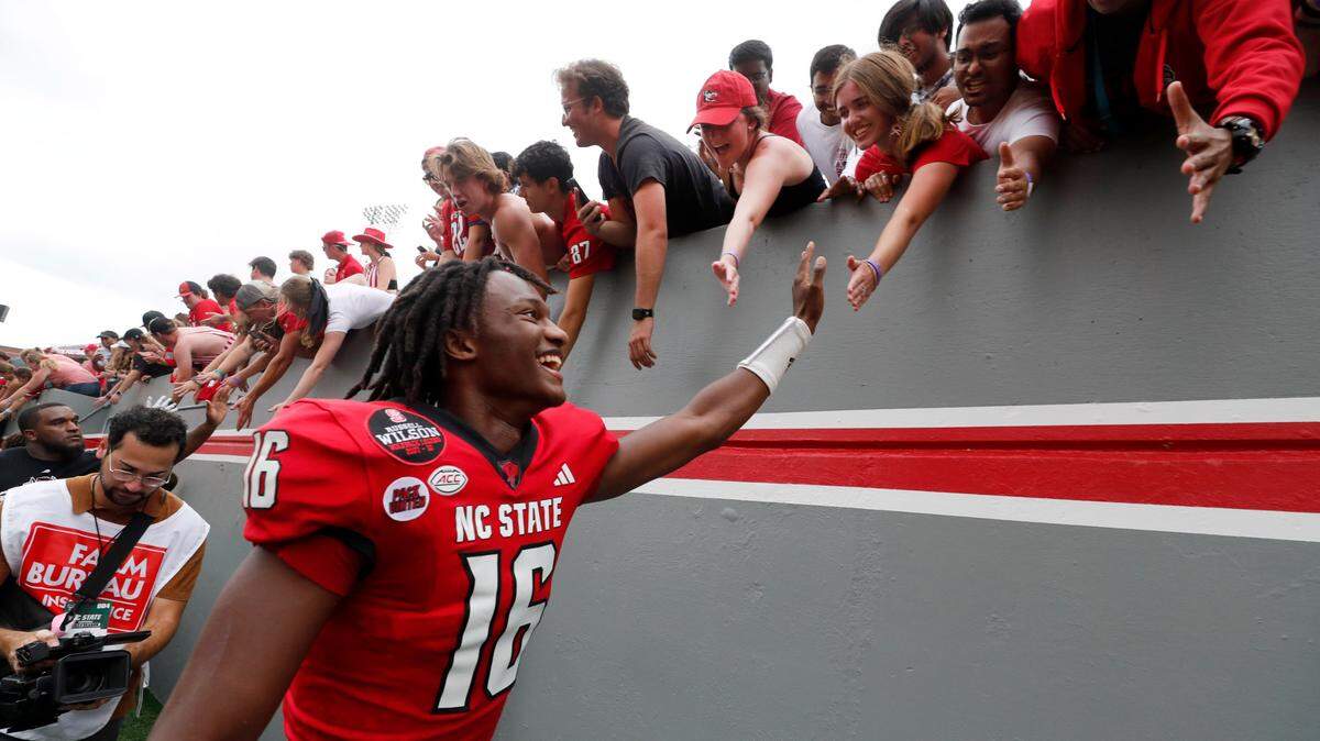 N.C. State freshman quarterback CJ Bailey high-fives fans as he walks off the field after N.C. State’s 30-20 victory over Louisiana Tech at Carter-Finley Stadium in Raleigh, N.C., Saturday, Sept. 14, 2024.