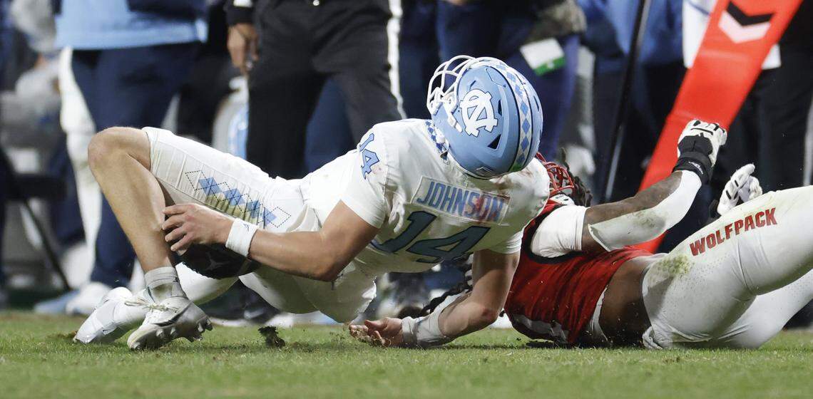 North Carolina quarterback Max Johnson (14) fumbles the ball while being tackled by N.C. State’s Tra Thomas (4) during the second half of N.C. State’s 42-19 victory over UNC at Carter-Finley Stadium in Raleigh, N.C., Saturday, Nov. 29, 2025.