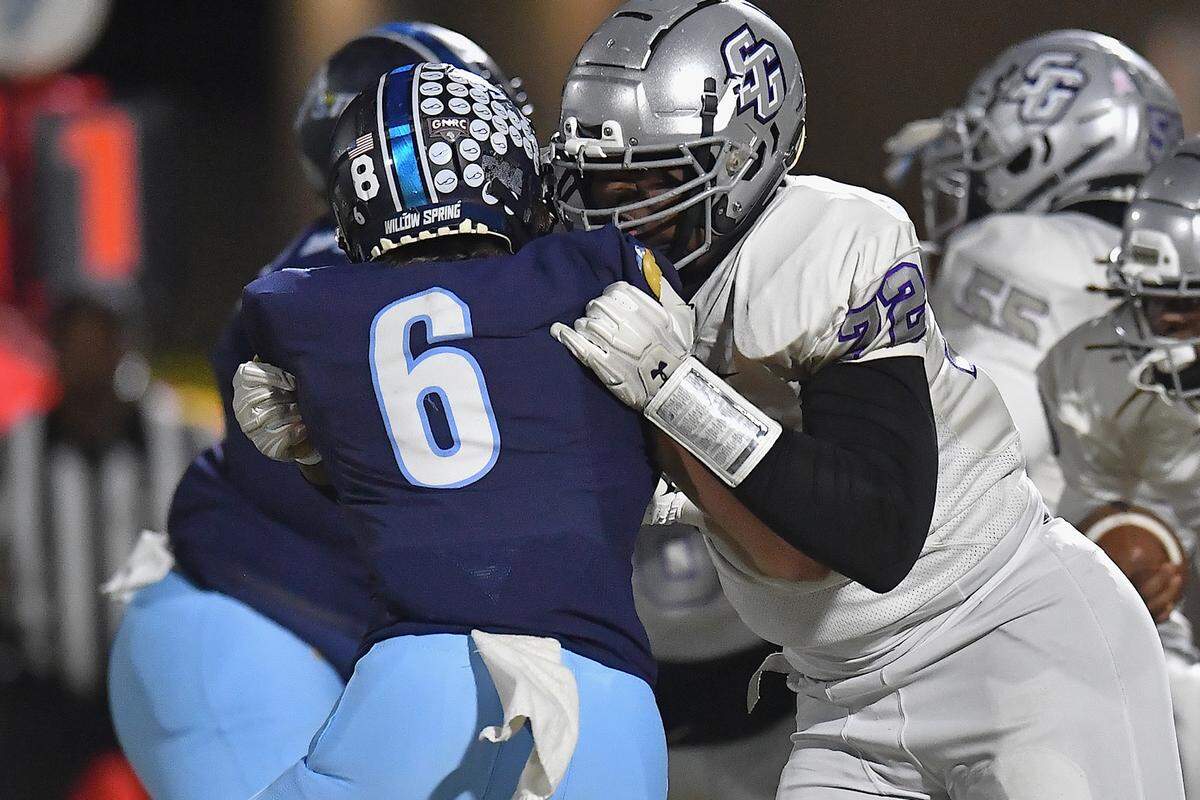 South Garner lineman Ekene Ogboko (72) grapples Willow Spring’s Charlie Hooks on the line of scrimmage during the first half. The Willow Spring Storm and the South Garner Titans met in a football game in Fuquay-Varina. N.C. on October 18, 2024.