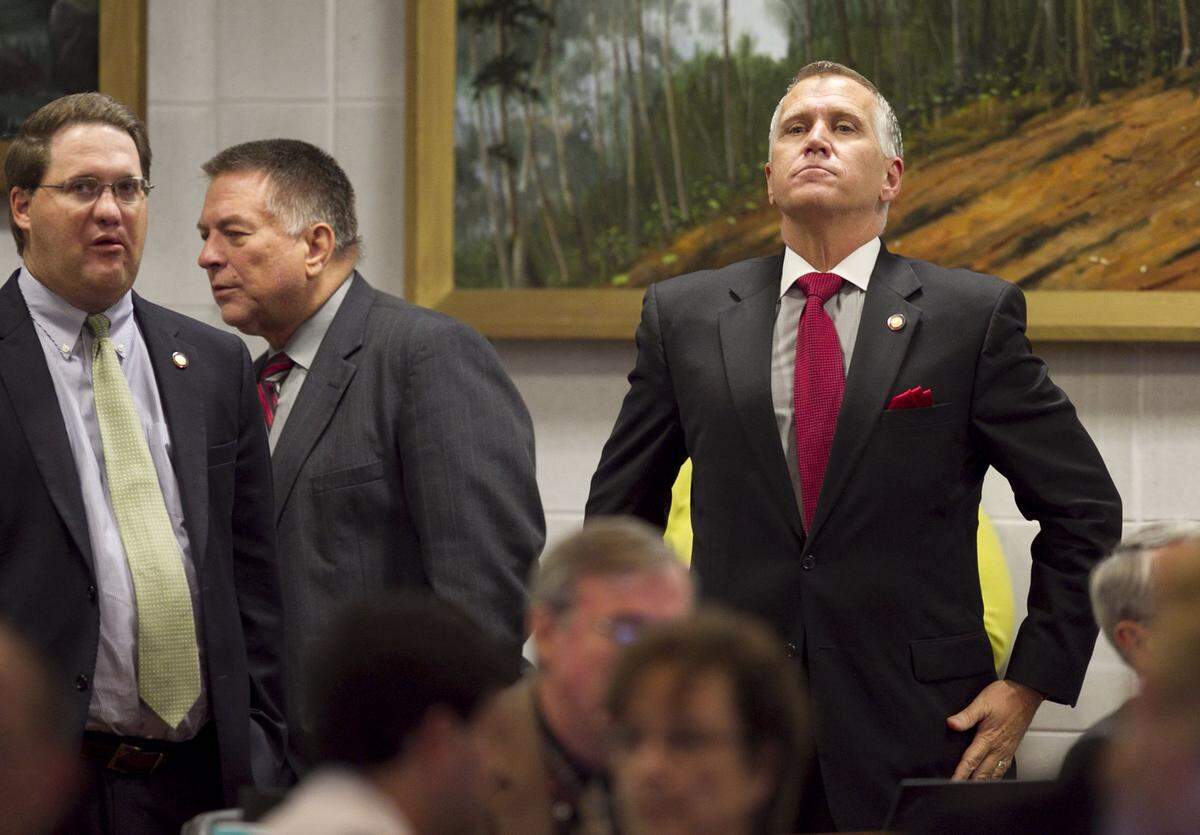 Speaker of the House, Thom Tillis stands in the back of the House chamber and listens to debate of Senate Bill 402, the Appropriations Act of 2013 in July 2013 at the North Carolina General Assembly.