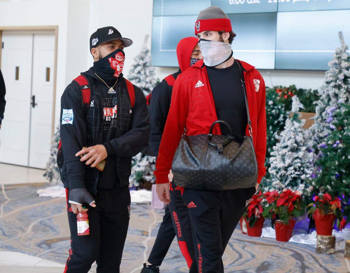 N.C. State safety Tanner Ingle, left, and linebacker Payton Wilson talk to each other as they and the Wolfpack players, coaches and staff leave the team hotel to head to the airport in San Diego, CA after the Holiday Bowl was cancelled in December 2021.