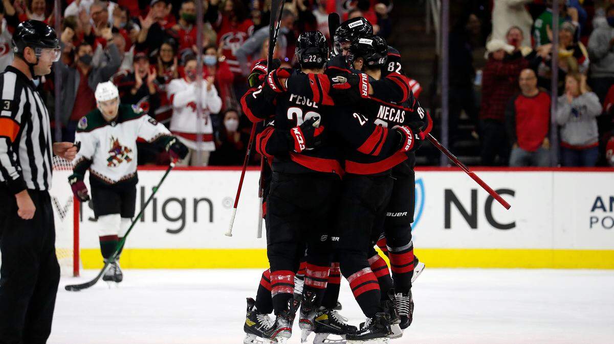 The Carolina Hurricanes celebrate a goal by Brett Pesce (22) against the Arizona Coyotes during the third period of an NHL hockey game in Raleigh, N.C., Sunday, Oct. 31, 2021. (AP Photo/Karl B DeBlaker)