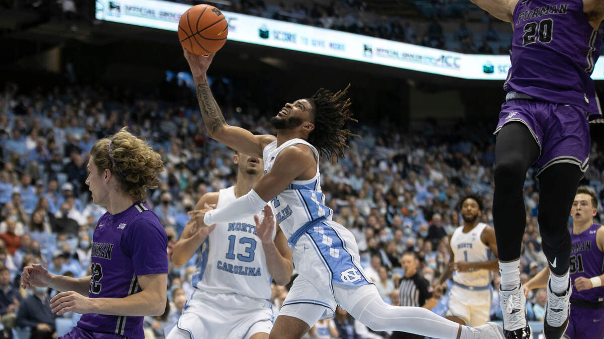 North Carolina’s R.J. Davis (4) drives to the basket under Furman’s Jalen Slawson (20) during the first half on Tuesday, December 14, 2021 at the Smith Center in Chapel Hill, N.C.