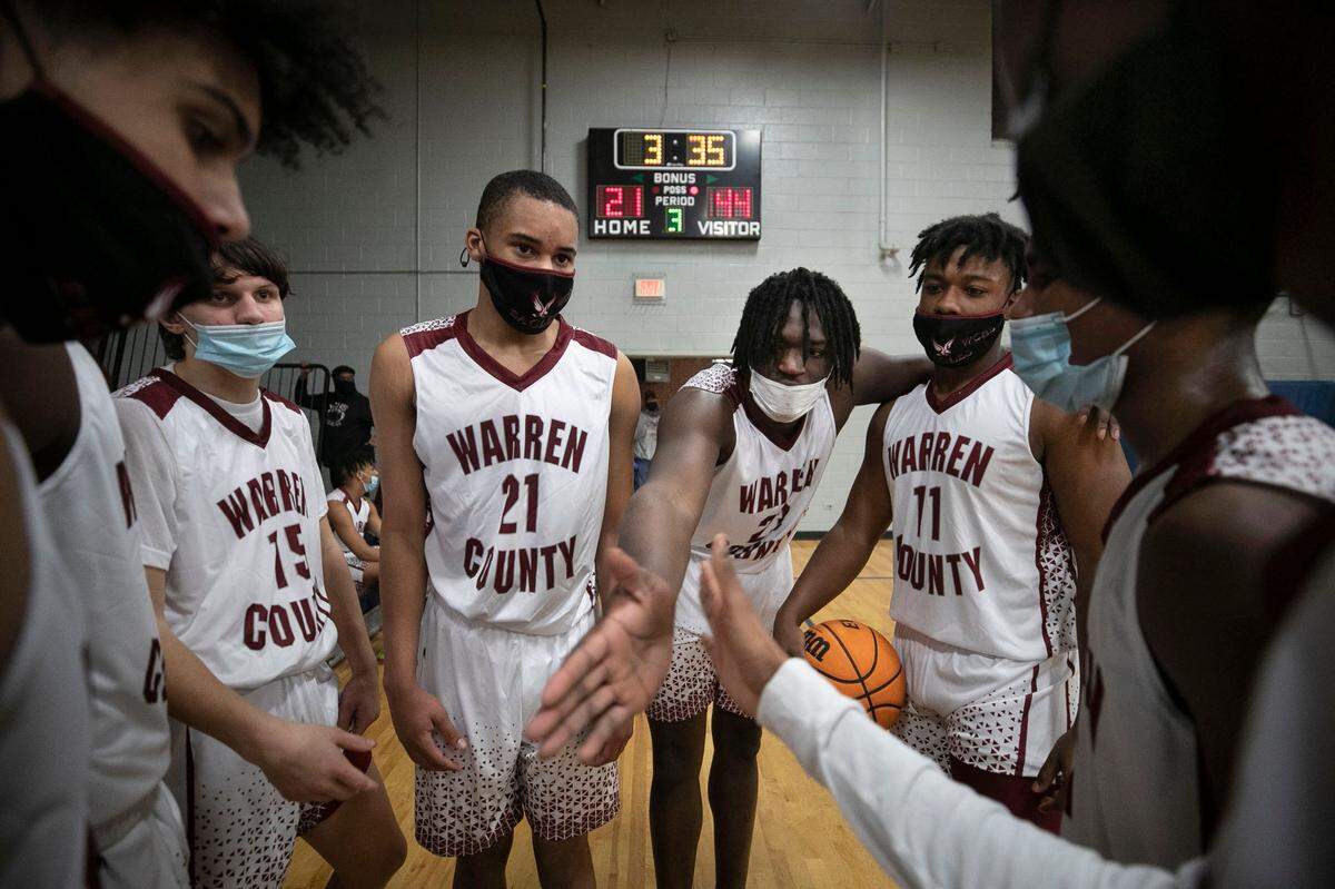 Warren County’s Jaylen Canty (23) reaches in to unify his teammates as they huddle during the third quarter against Webb High School on Friday, January 29, 2021 in Warrenton, N.C.