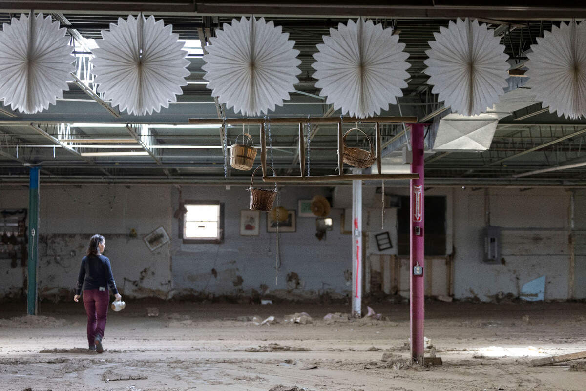 Whitney Brasington, walks among the remains of a mixed used building she and her husband George Brasington own in Micaville, N.C., on Tuesday, March 11, 2025. The former Taylor Toggs building was destroyed by flood waters from Hurricane in September 2024.