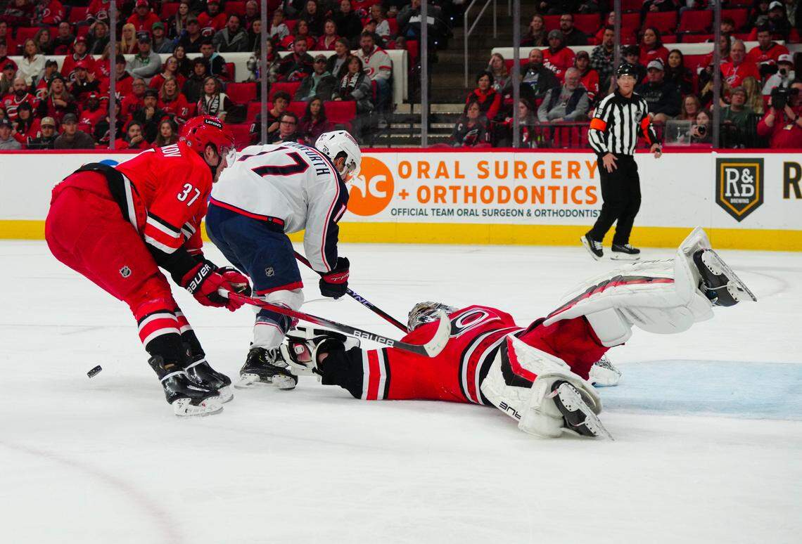 Nov 26, 2023; Raleigh, North Carolina, USA; Carolina Hurricanes goaltender Pyotr Kochetkov (52) and right wing Andrei Svechnikov (37) stop the scoring attempt by Columbus Blue Jackets right wing Justin Danforth (17) during the second period at PNC Arena. Mandatory Credit: James Guillory-USA TODAY Sports